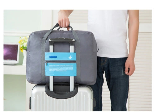 Foldable duffle bag attached to suitcase handles