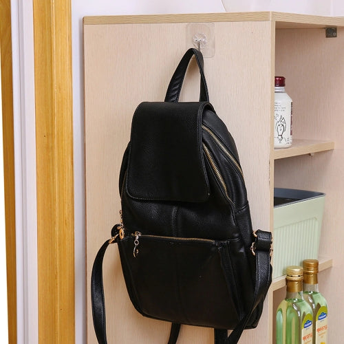 Black backpack hanging using a clear adhesive wall hook